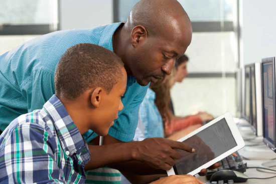 Teacher instructs student using his tablet computer.