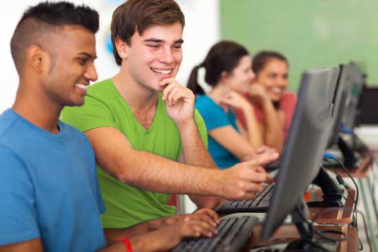 High school students conversing in a computer lab.