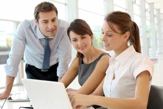 Three educators view laptop.