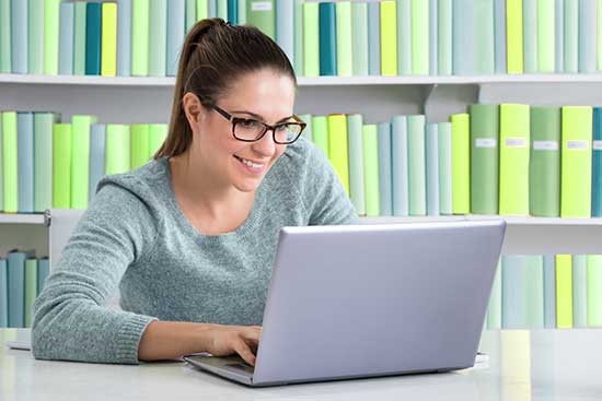 Woman browsing courses on laptop.